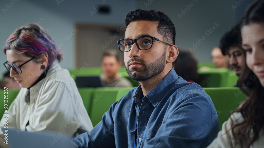 Fototapete young handsome male student studying in university with diverse multiethnic classmates. young man is