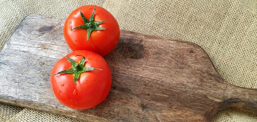 Ripe tomatoes on a wooden board close-up. Juicy tomatoes. Red tomatoes on the table. Fresh tomatoes for cooking.