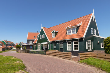 Fototapeta na wymiar Street in the Dutch village of Marken with colorful wooden houses on the peninsula at the Markermeer.