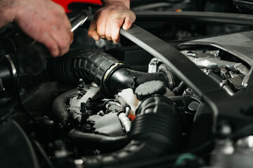 Fototapeta na wymiar Auto mechanic checking engine in garage repair service