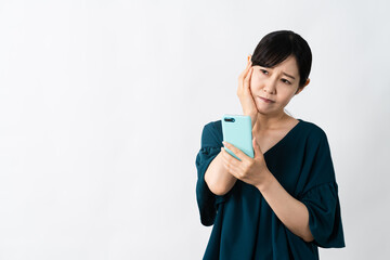 スマートフォンを持ちながら頭を抱える若い女性