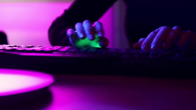 Close-up of male hands fast typing on computer keyboard at home, office in neon. Online job, freelance, programmer, journalist. Concept of business, gaming, modern technologies, freelance