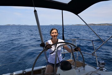 Naklejka premium Woman at the helm of Croatia sailboat