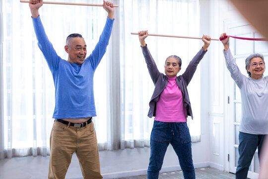 Seniors  stretching exercise together at retirement center. Old people exercise at home. Retired Person exercising at nursing home. Active seniors exercising in home. Sport and recreation concept.