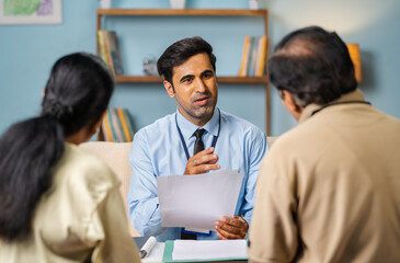 Shoulder shot, indian banker explaining about future investment plans or pension scheme offer to...