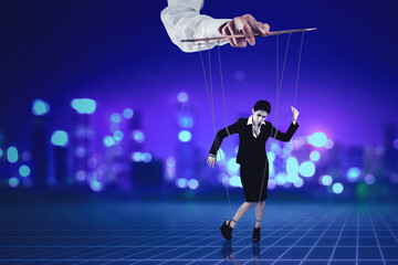 Fototapeta na wymiar Puppeteer holding businesswoman on strings