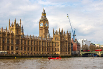 Tourist speed boat passing in front of the Palace of Westminster, houses of parliament, big ben...