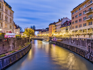 Ljubljana River and river side old town lit up with Christmas lights at dusk, Slovenia