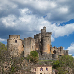 Les ruines du château médiéval de Bonaguil (Lot-et-Garonne) dominant les maisons du village - obrazy, fototapety, plakaty