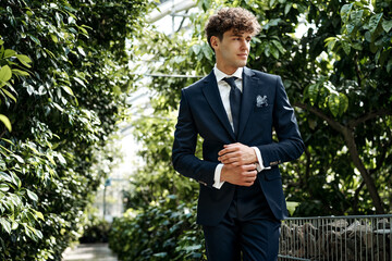 Photo of young handsome man in classic suit over green garden - 601404098