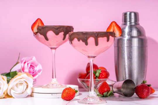 Sweet chocolate strawberry cocktail, cute pink strawberry martini or daiquiri creamy drink, with fresh strawberry garnish and choco drizzles, on high-colored pink background