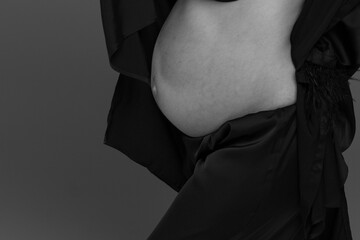 pregnant belly close up, person in a black shirt - obrazy, fototapety, plakaty