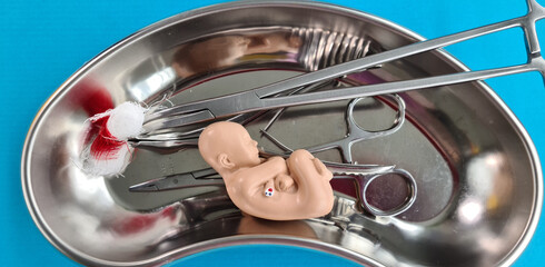 Abortion concept with baby fetus and medical tool