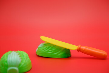 toy cabbage and knife isolated on red background. Attachable and detachable cabbage vegetable toy.