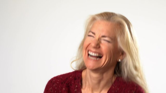 Closeup of laughing out loud portrait of happy smiling beautiful 50s middle aged mature woman on white background. Anti age face beauty, skin and body care, wellness self care concept