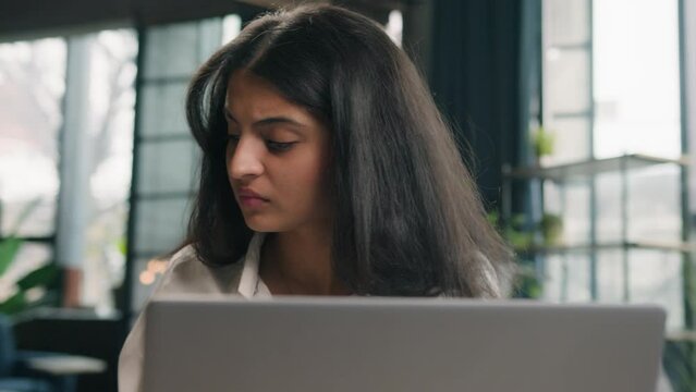 Indian anxious woman with computer working business problem in office Arabian dissatisfied girl worker upset confused businesswoman work with laptop online mistake trouble bad results job difficulties