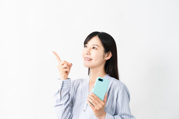 スマートフォンを持ちながら指差しをする若い女性