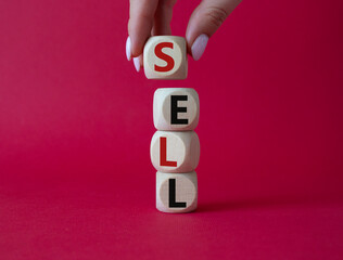 Sell symbol. Concept word Sell on wooden cubes. Businessman hand. Beautiful red background. Business and Sell concept. Copy space.