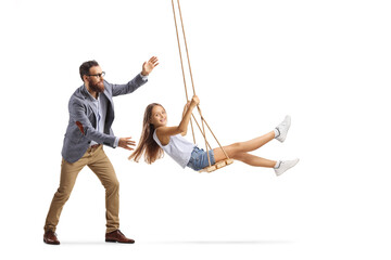Full length shot of a father pushing a girl on a swing - obrazy, fototapety, plakaty