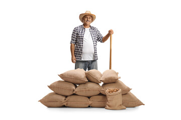 Smiling farmer standing behind burlap sacks of potatoes