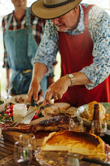 Grill Master at Work: Senior Man Cutting Barbecued Meat at Outdoor Gathering