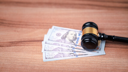 The gavel on a dollar bill in a courtroom represents the complex interplay between alimony law,...