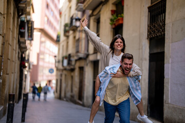 Young man carrying his girlfriend and enjoying a vacation with her 