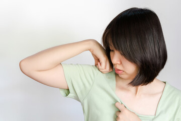 Woman raising her arms because of sweating under armpits.