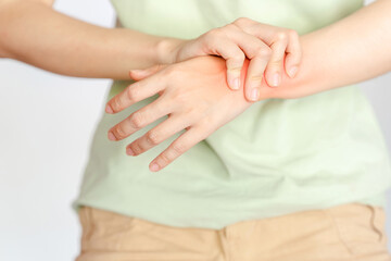 Fototapeta na wymiar A woman holding her wrist due to an injury or rheumatoid arthritis.