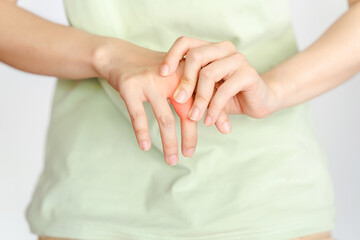 Fototapeta na wymiar A woman touches her knuckle because of an injury or rheumatoid arthritis.