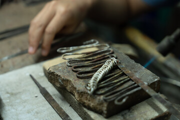 Jeweler at work in jewelry. Desktop for craft jewelry making with professional tools. Close up view of tools. Thailand.	