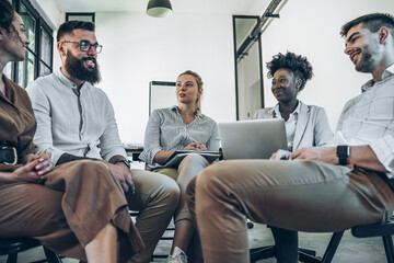 A diverse, casual business team collaborates in the office, brainstorming and creating innovative solutions and fostering in dynamic creative environment.