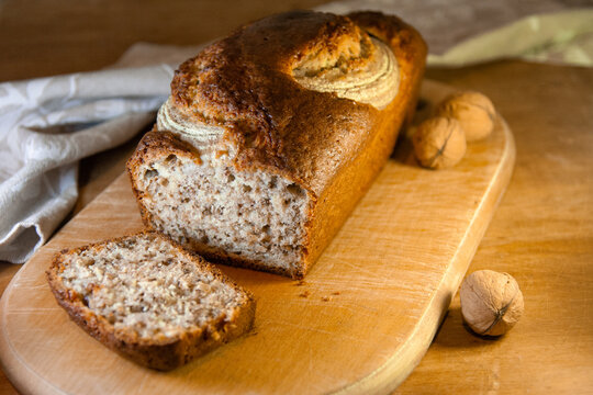 Delicious banana bread with nuts sliced on wooden board