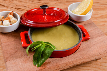 lentil soup, lemon, fresh pepermint and croutons with red pot presentation