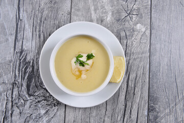 lentil soup with lemon and butter sauce, parsley, in  white bowl