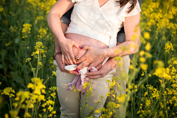 Femme enceinte dans la nature, parents avec les mains en forme de coeur, bola de grossesse