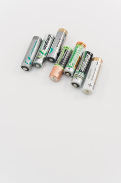 immagine editoriale illustrativa in primo piano di batterie ricaricabili di diversi produttori formato stilo AA su superficie bianca