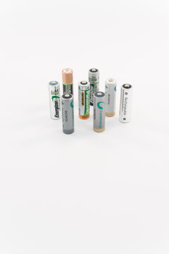 immagine editoriale illustrativa in primo piano di batterie ricaricabili di diversi produttori formato stilo AA su superficie bianca