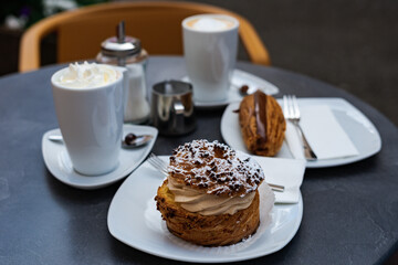 Typical french breakfast at a patisserie in Wissembourg, France with eclairs and coffee
