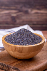Blue poppy seeds. Spices concept. Blue poppy seeds on wooden background. Close up