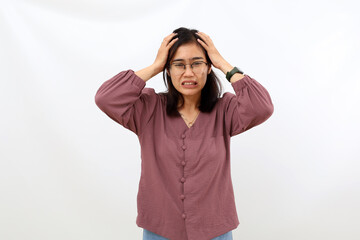 Stressed young asian woman standing while holding her head. Isolated on white background