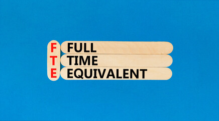 FTE Full time equivalent symbol. Concept words FTE Full time equivalent on wooden sticks. Beautiful blue table blue background. Business and FTE Full time equivalent concept. Copy space.