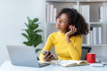 Cute young woman curly hair wearing headphones using smartphone to listen to music happy and relax listening to music at home.