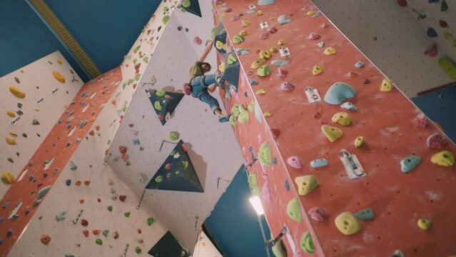 Man rope climbing a wall in indoor climbing centre