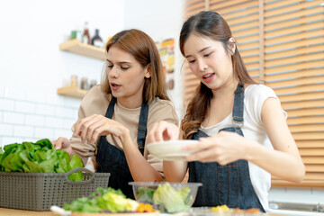 Smiling women preparing fresh healthy salad vegetables. woman sitting at pantry in a beautiful...