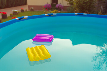 Two inflatable pillows lie on the surface of the water in the pool