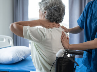 Physiotherapist working with asian elderly female patient woman having chiropractic back...