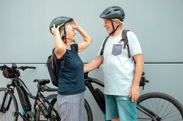 Happy caucasian senior couple enjoying sport activity with their electric bicycles - healthy active...