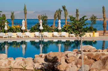 Hotel Movenpick Resort and SPA Tala Bay Aqaba 5 stars on the Red Sea in Jordan. Hotel area with many pools surrounded by palm trees. Aqaba, Jordan - December 06, 2009