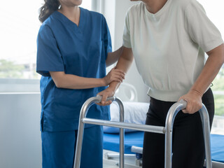 Asian senior care nurses and grandmothers provide caring support to elderly women hand clasp to encourage exercising with elder disabled person patient with caregiver in nursing care.